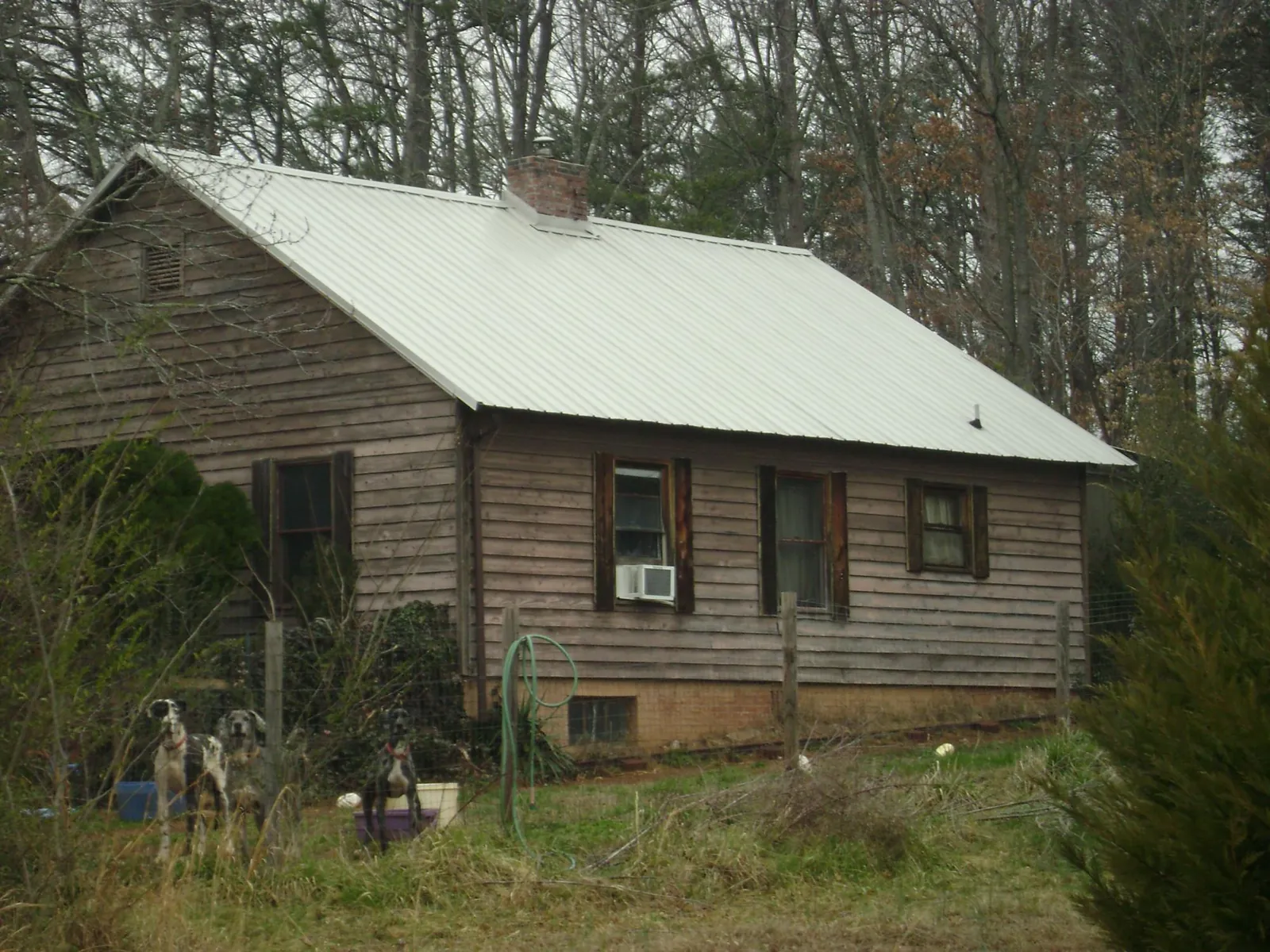 White metal roof on an old wood sided farmhouse, from a Metal Roof Installation job in Madisonville